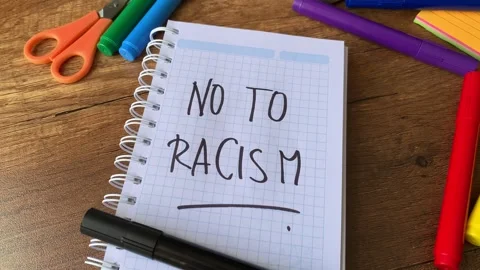 Video of a notebook with the phrase "no to racism" on a table. Stock Footage 262453204