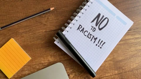 Video of a notebook with the phrase "no to racism" on a table. Stock Footage 262453327