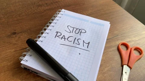 Video of notebook with phrase "stop racism" on a table. Stock Footage 262453229