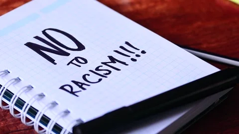 Video of notebook with phrase "stop racism" on a table. Stock Footage 262598572