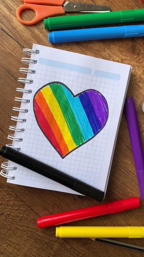 Video of notebook on wooden table with hand drawn LGBTQ+ heart. Stock Footage 262452041