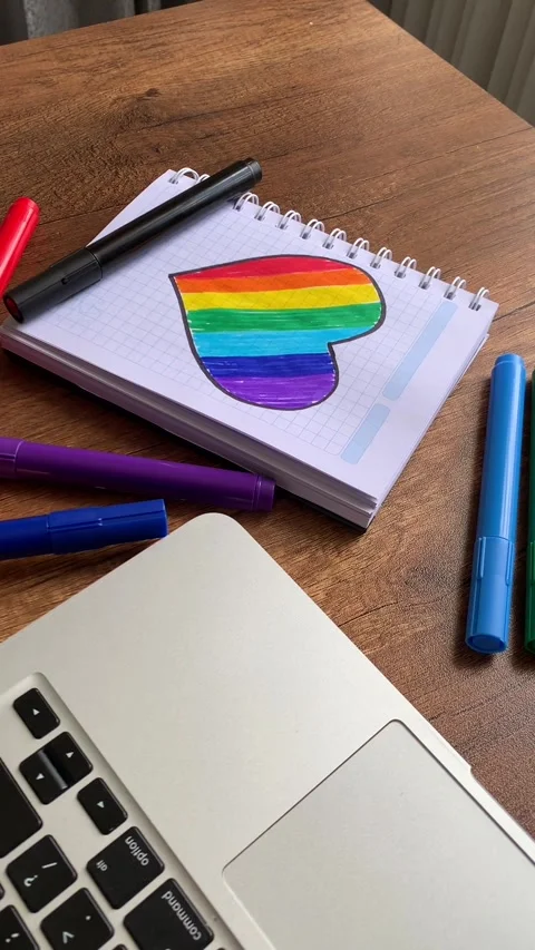 Video of notebook on wooden table with hand drawn LGBTQ+ heart. Stock Footage 262452280