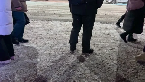 The video opens with a panoramic view of an illuminated bus stop Stock Footage 328405600