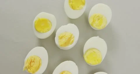Video of overhead view of halves of hard boiled eggs on grey background Stock Footage 342594201