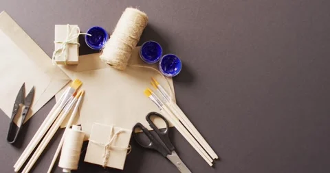 Video of parcels with twine, card, scissors, brushes and paint on grey Stock Footage 331207886
