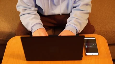 Video of a person using a laptop to check cryptocurrency charts while typing Stock Footage 322095874
