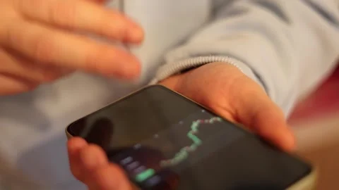 Video of a person using a laptop to check cryptocurrency charts while typing Stock Footage 322095887