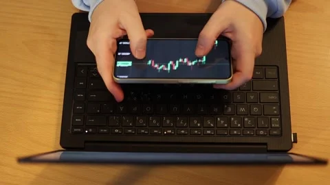 Video of a person using a laptop to check cryptocurrency charts while typing Stock Footage 322095895