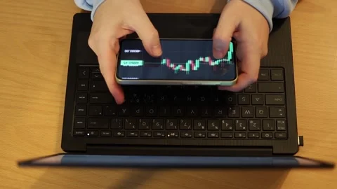 Video of a person using a laptop to check cryptocurrency charts while typing Stock Footage 322095897