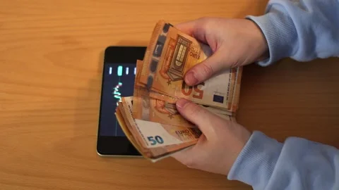 Video of a person using a laptop to check cryptocurrency charts while typing 動画素材 322095989