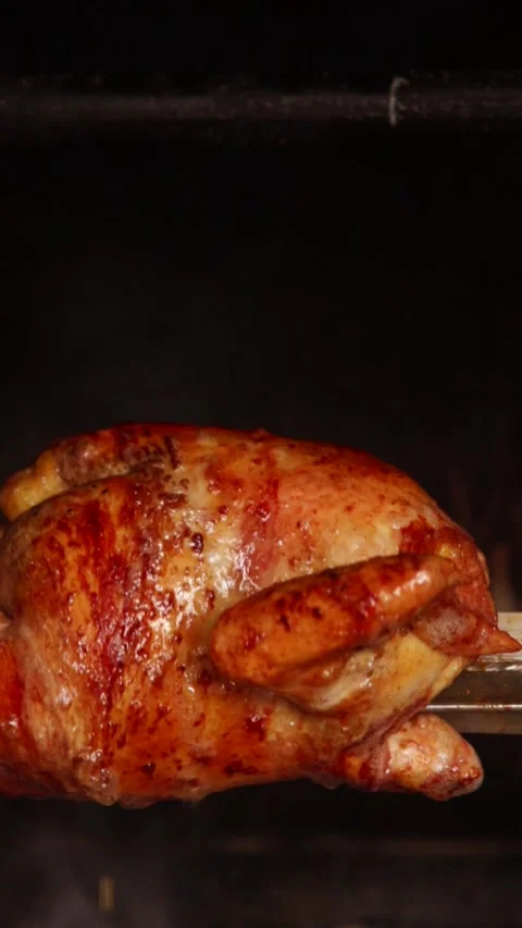 Video of peruvian food called "pollo a la brasa" going around in an oven Stock Footage 231541395