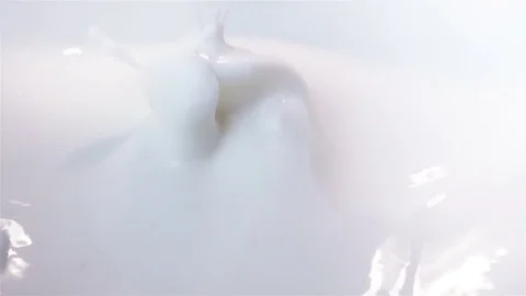 Video of pieces of orange falling into yogurt in real slow motion Stock Footage