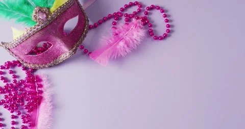 Video of pink masquerade mask with feathers and mardi gras beads on lilac Stock Footage 331294858