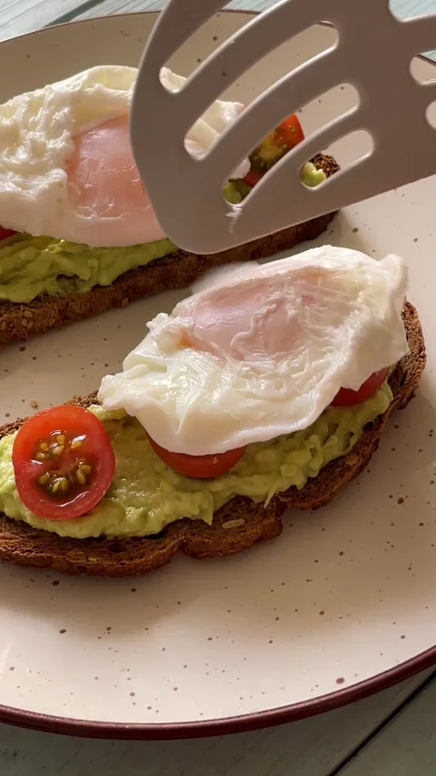 Video of a poached egg that goes into a bread with avocado cream, cherry to.. Stock Footage 287860540