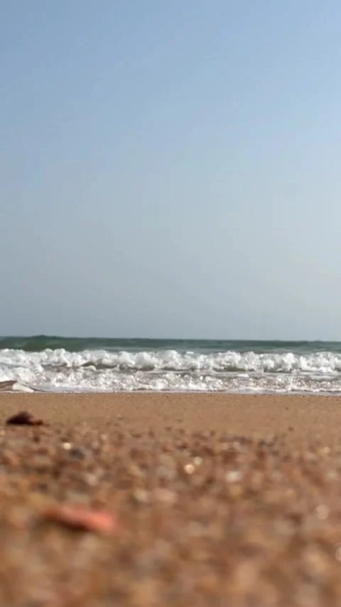 Video of powerful ocean waves crashing on sandy beach shoreline Vídeos de archivo 333605197