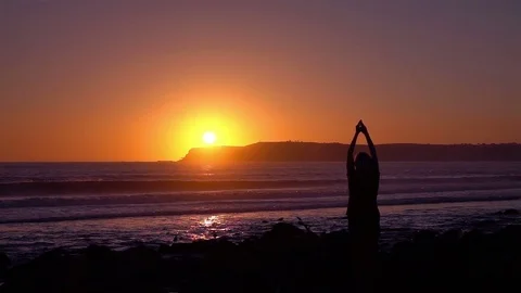 Video of practicing yoga at the sunset in real slow motion Stock Footage 77404414