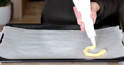 Video of the process of making eclairs or choux pastries. woman lays out custard Stock Footage 150096639
