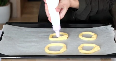 Video of the process of making eclairs or choux pastries. woman lays out custard Stock Footage 150096694