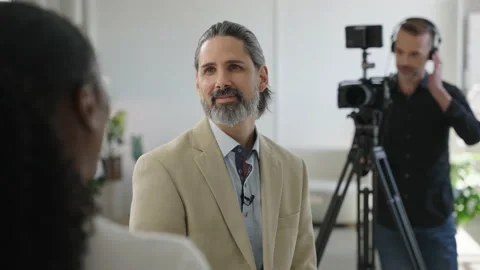 Video Production Interview in Business Setting Camera Man Videographer Filming Stock-Footage 194509072