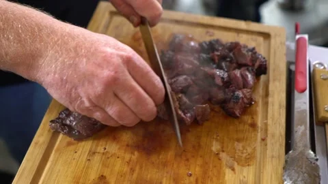 Video of a professional chef cutting a beef steak on a wooden cutting board Stock-Footage 150576761