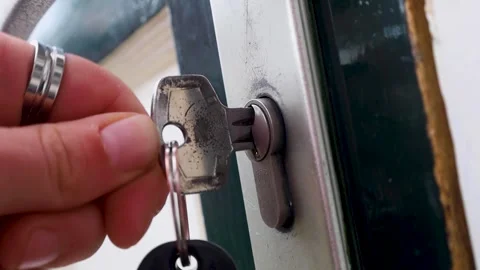 Video putting a key inside the front door lock and turning the key. Stock Footage 341674828