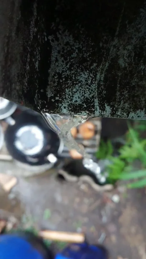 Video of rainwater flowing from the drainage gutter to the ground in high angle Stock Footage 284122353