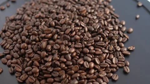 Video of roasted coffee beans falling from above. Video stock 329593872