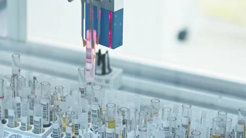 A video of a robot arm of an automated lab picking up one empty test tube and Stock Footage 232686846