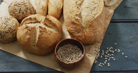 Video of rolls and bread on baking paper on wooden worktop Stock Footage 335452711