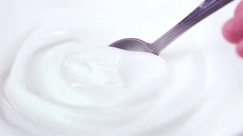 Video of scooping yogurt in real slow motion Stock Footage