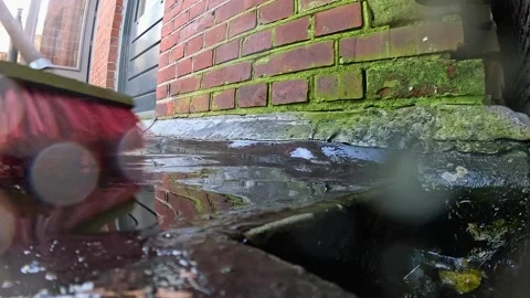 Video scrubbing water into a drain while cleaning a deck. Видео 332800214