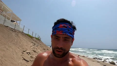 Video selfie portrait of a man without a polo shirt running along the beach with Vidéo 195961697