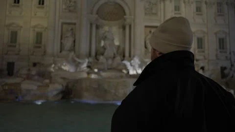 Video shifting focus back and forth from man to the Trevi Fountain. Stock Footage 266862224