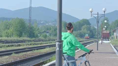 The video shootage of the boy standing with his bike at the railway station. Stock Footage 95941244