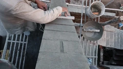 A video shot of the worker applying plaster to the parapet wall, creating a Video stock 295782953