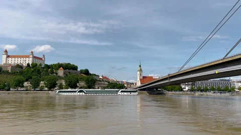 A video showcasing a serene riverside view with Bratislava Castle on a hill. Video stock 298615872