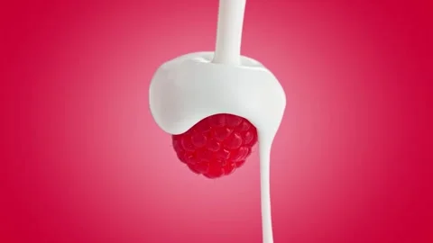 A video showcasing a spoonful of yogurt with raspberry on a red background Vídeo Stock 329925036
