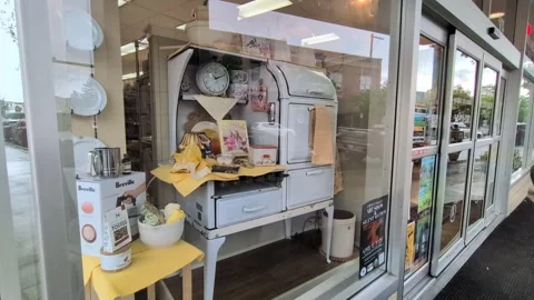 A video showing a charming retro kitchen display through a storefront window Stock Footage 345693128