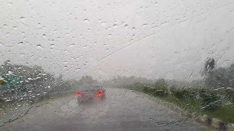 A video shows car windshield wipers clearing heavy rainwater during a sceni.. Video stock 313381850