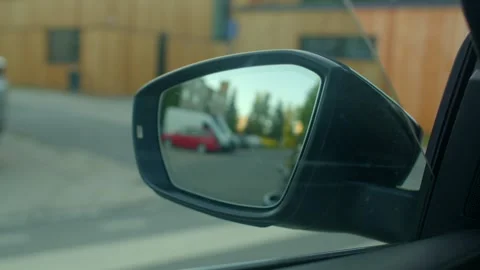 Video shows closeups of a rear view mirror reflecting scenes while driving Stock Footage 314346265
