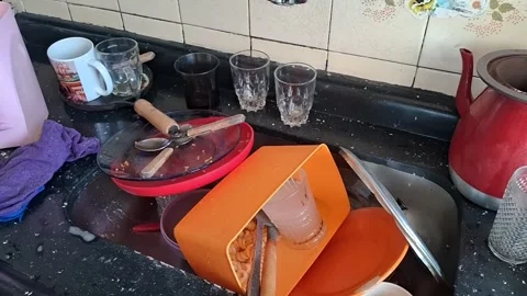 A video shows a cluttered kitchen countertop with dirty dishes and utensils Stock Footage 340200941