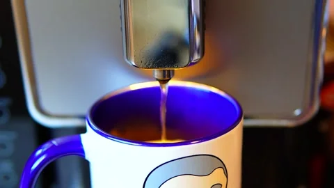 The video shows a coffee machine pouring coffee into a blue and white mug. Stock Footage 299077980