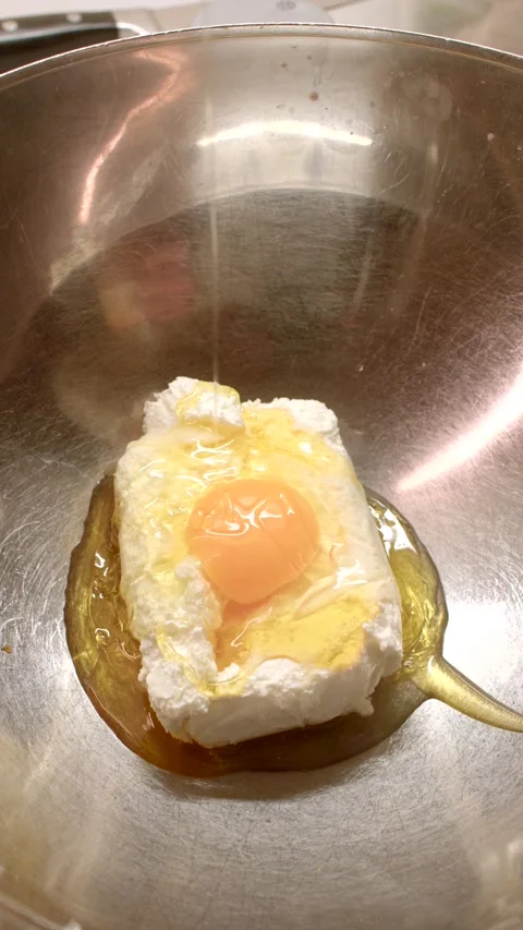 This video shows creating a dish with cheese, fried egg, and honey Stock Footage 311002095