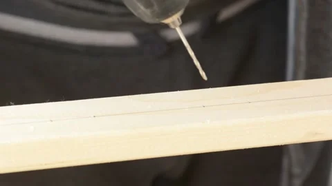 This video shows a drill being used to make hole in a plank of wood. Stock Footage 130428374