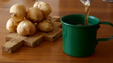 Video shows putting tea in a cup, next to a plate of cheese bread Stock Footage 230465313