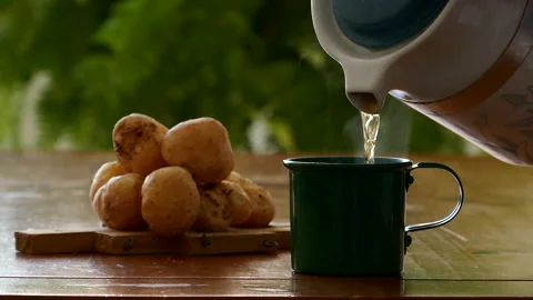 Video shows putting tea in a cup, next to a plate of cheese bread Stock Footage 230465321