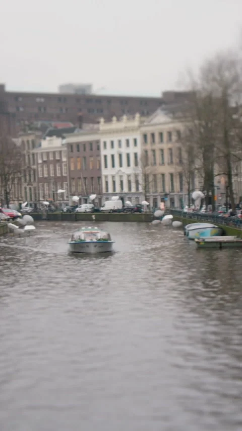 A video shows serene nature with waves, a boat, and buildings 動画素材 319637123