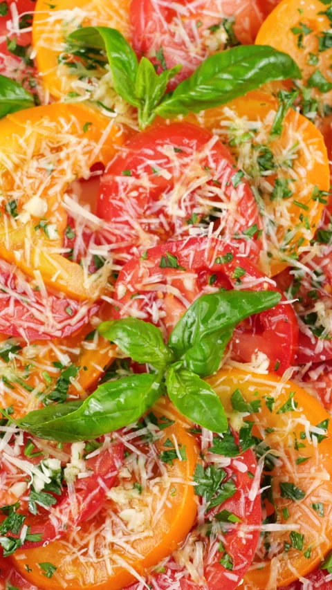 This video shows sliced red and yellow tomatoes on a rotating plate.  Vídeo Stock 341487815