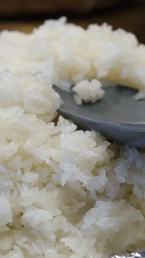 This video shows a top view of a plastic spoon scooping fried rice from a Video stock 316954022