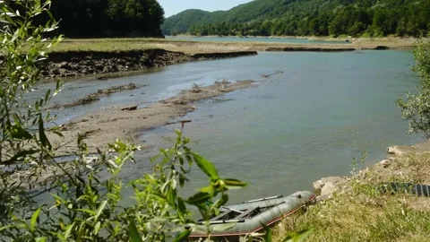 This video shows tranquil nature, featuring a lake, boat, and river Stock Footage 313936228